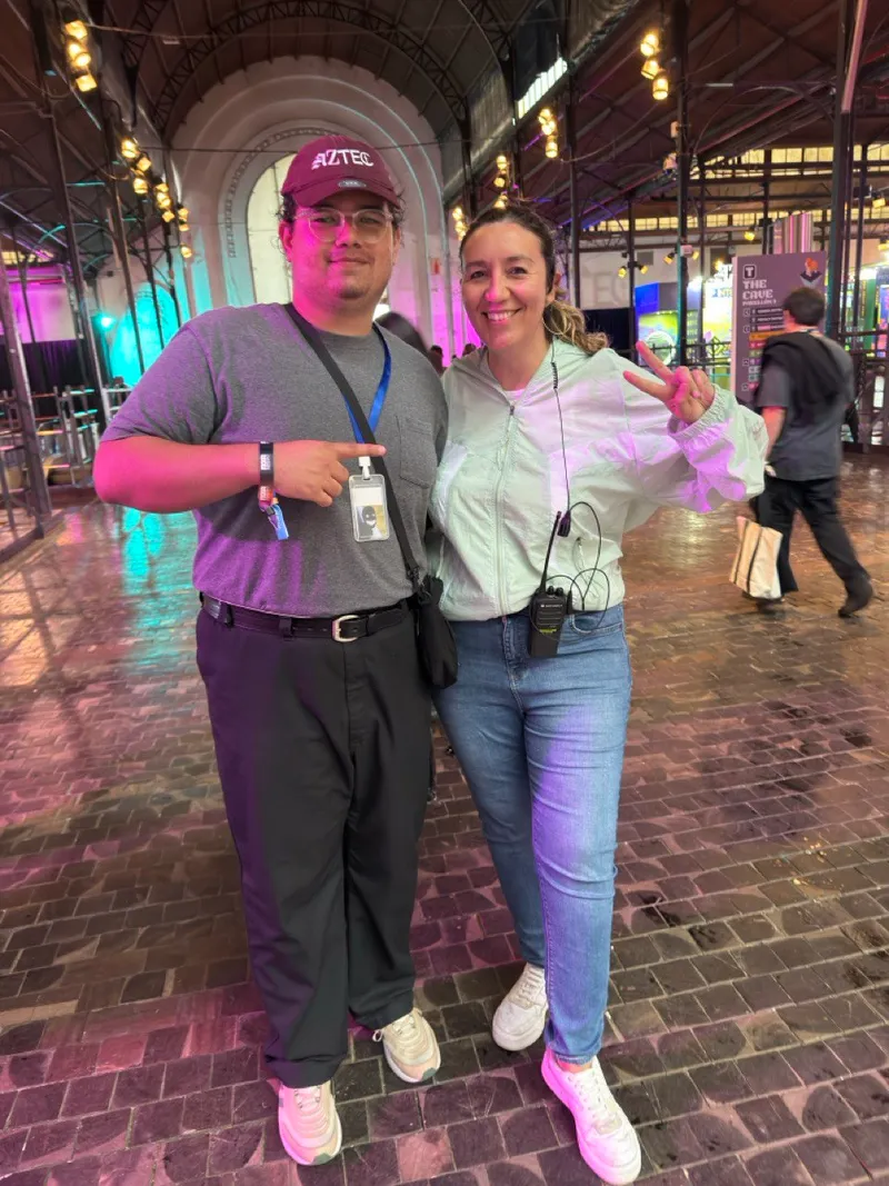 Gerson with Ornella at Devconnect 2025, arched industrial hall with teal and purple event lighting